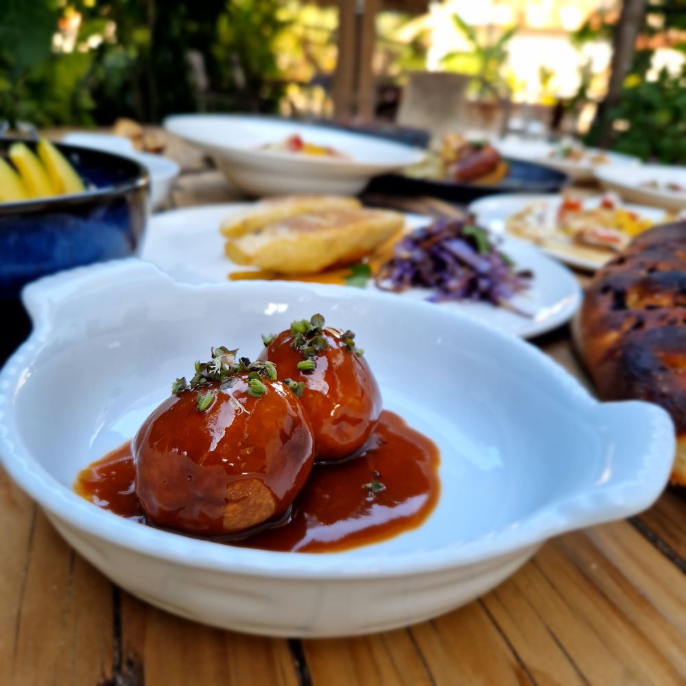 A glazed dish in a white bowl on a table in the garden