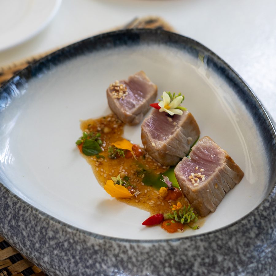 Seared tuna with an orange sauce in a stone bowl
