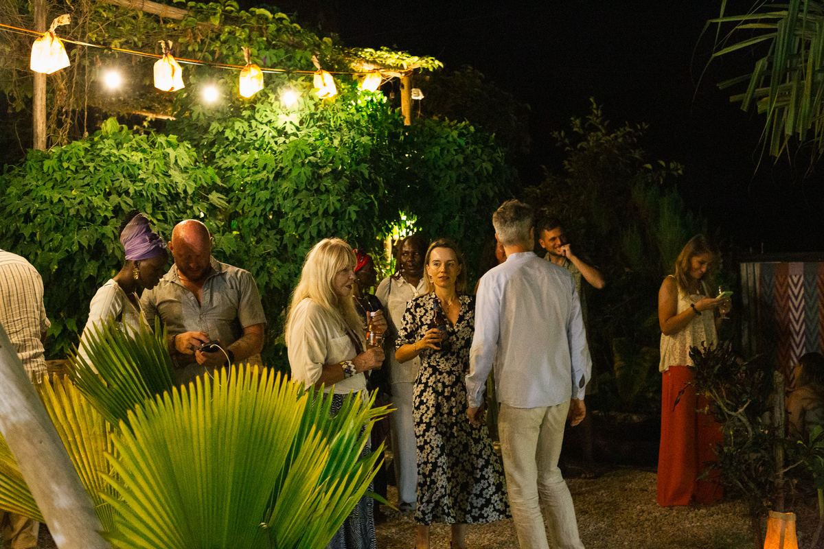 Guests talking in the garden under string lights at the Food Night Market