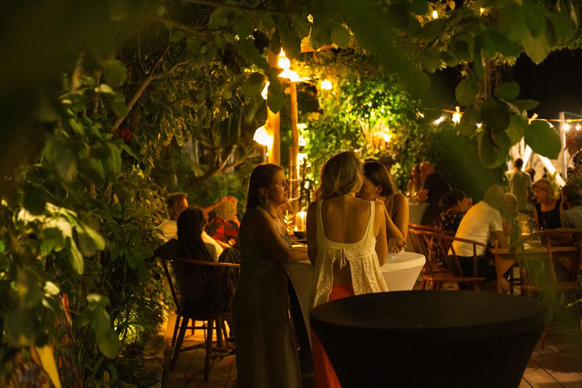 Guests at tables in the garden at night