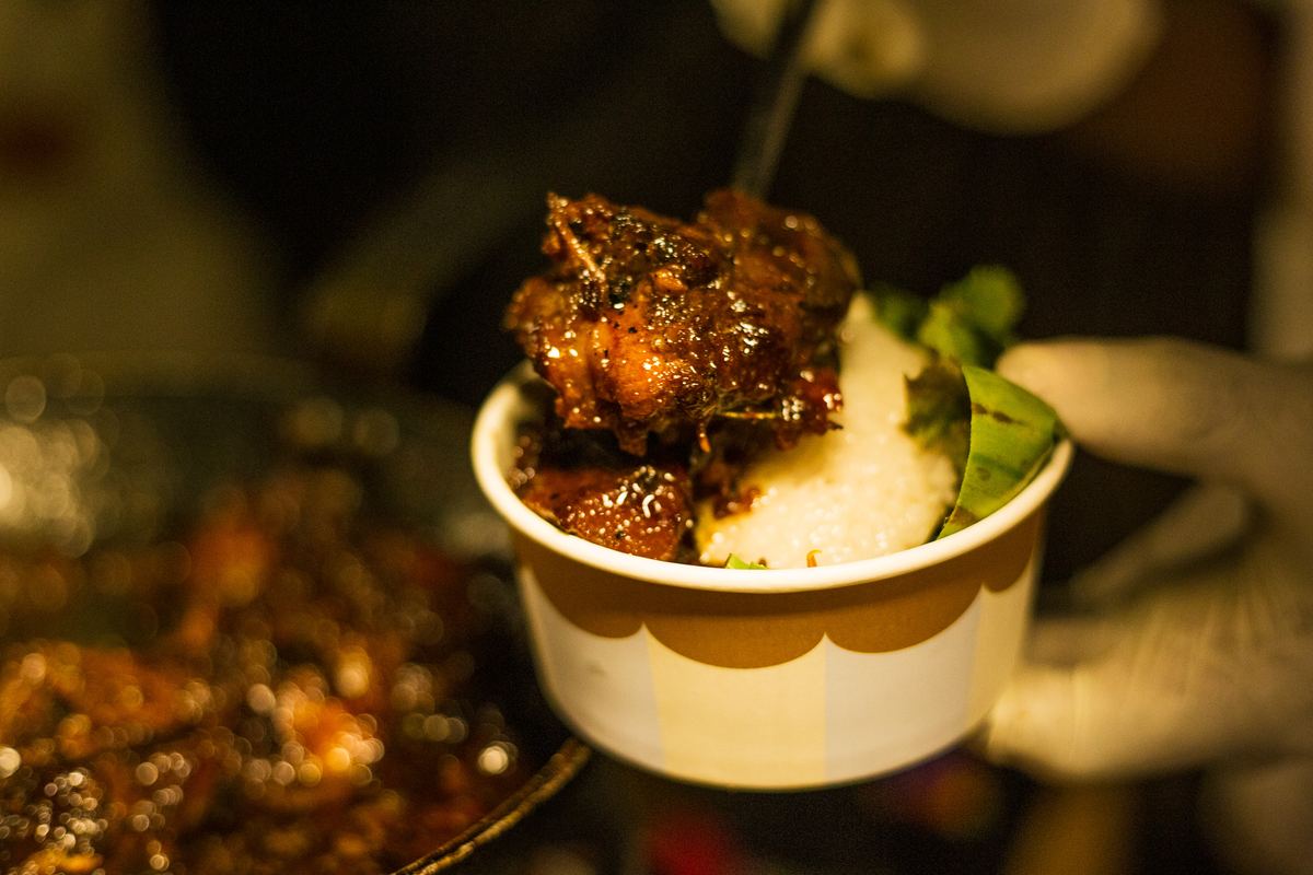 A bowl of rice and braised meat served at a market stall