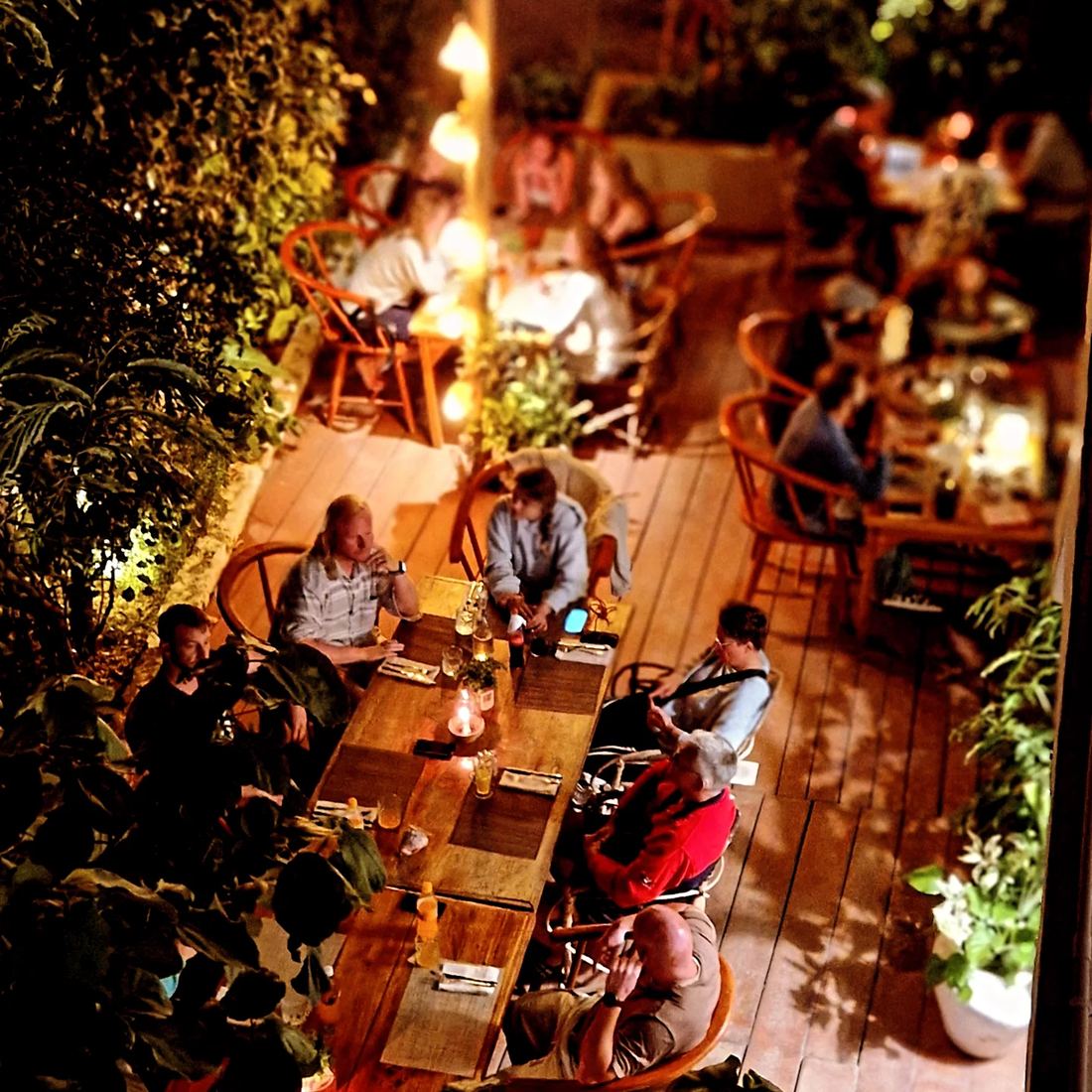 Guests at dinner on the garden deck, seen from above