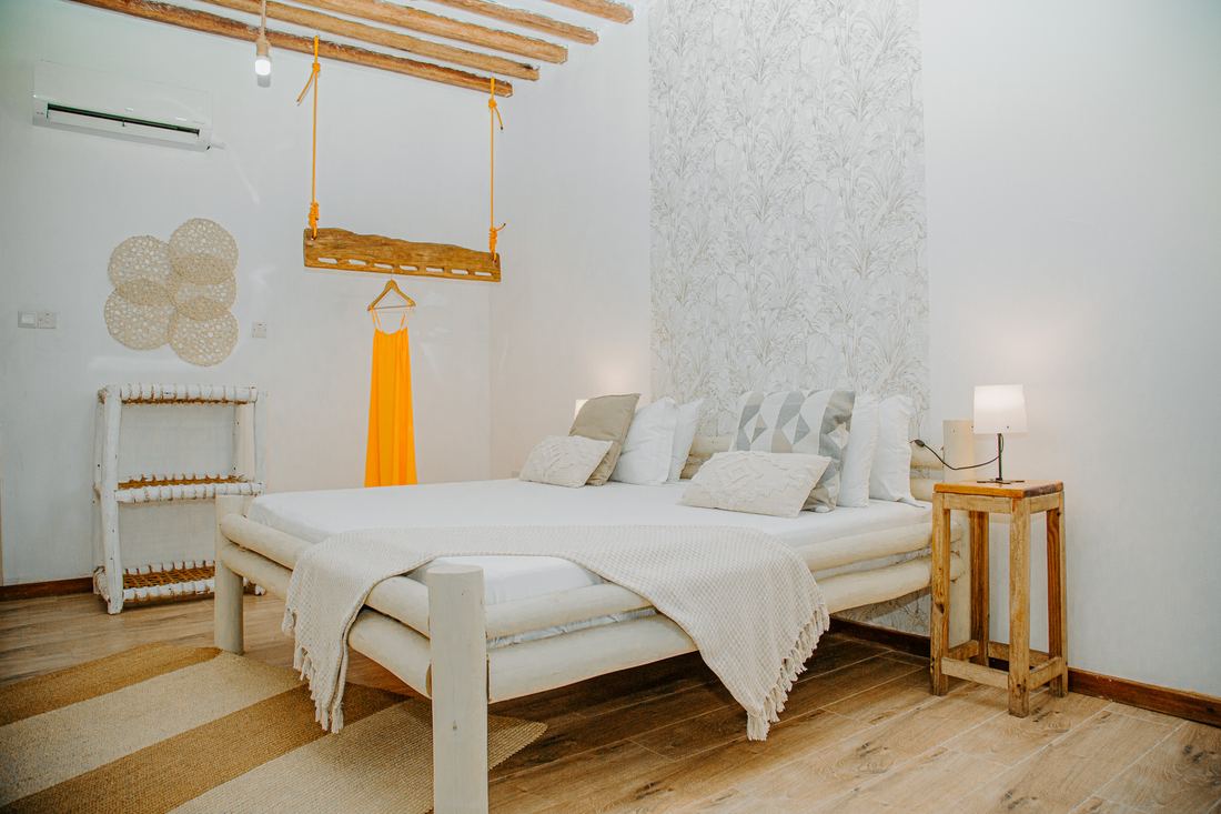 Room with a white bed and timber ceiling beams