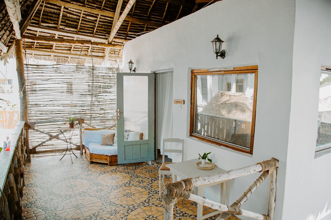 Covered terrace with a thatched roof and patterned floor tiles